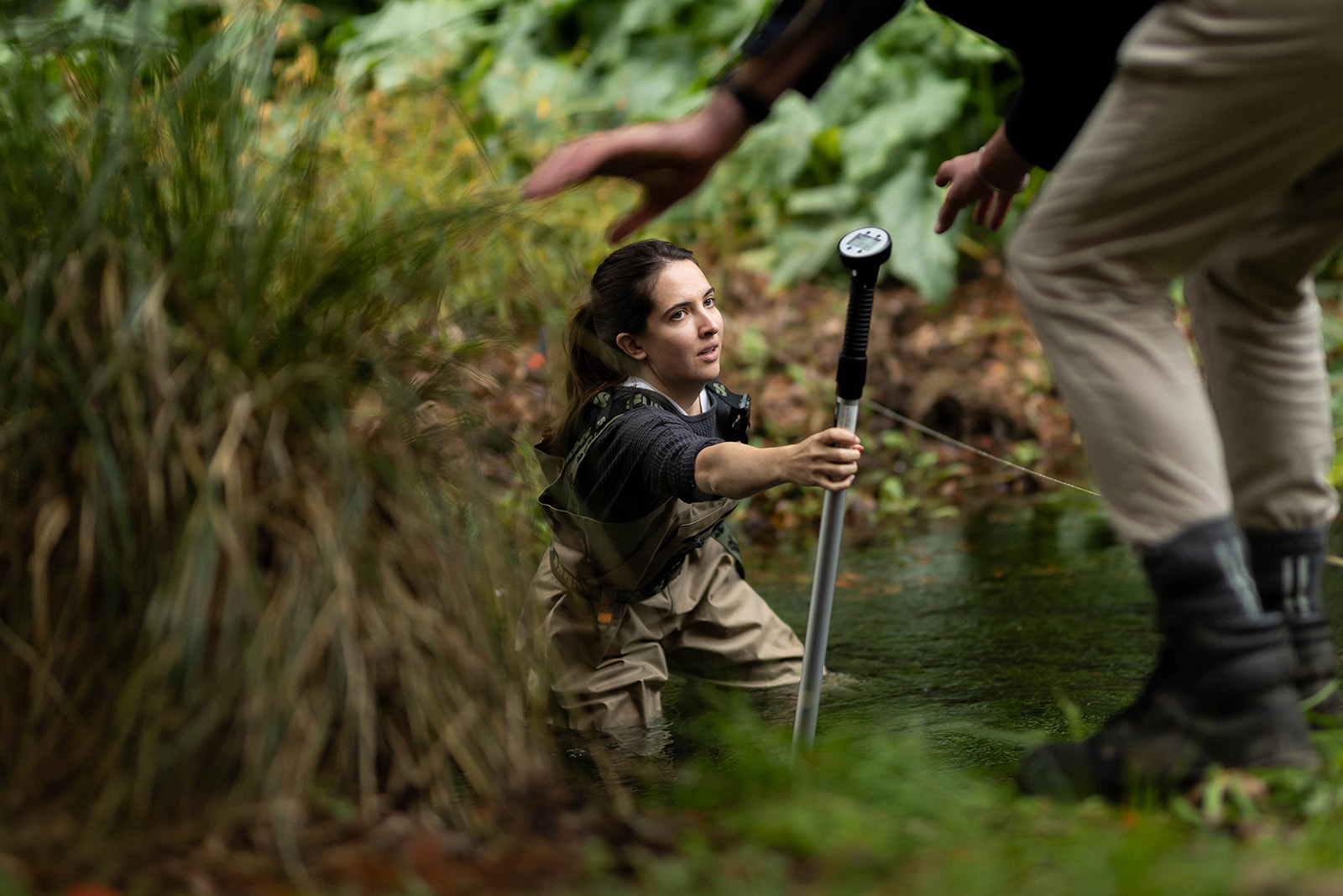 Mathilde Faraud performing investigations in a waist-deep river - Hydrogeology Earthtech Consulting